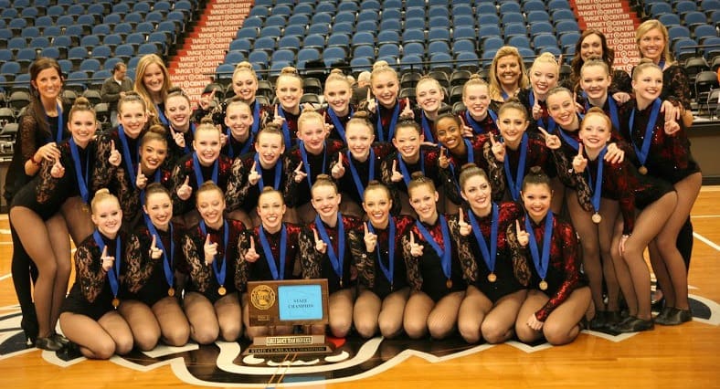 2012-2013 Lightning Dance Team posing with their championship trophy on the court.
